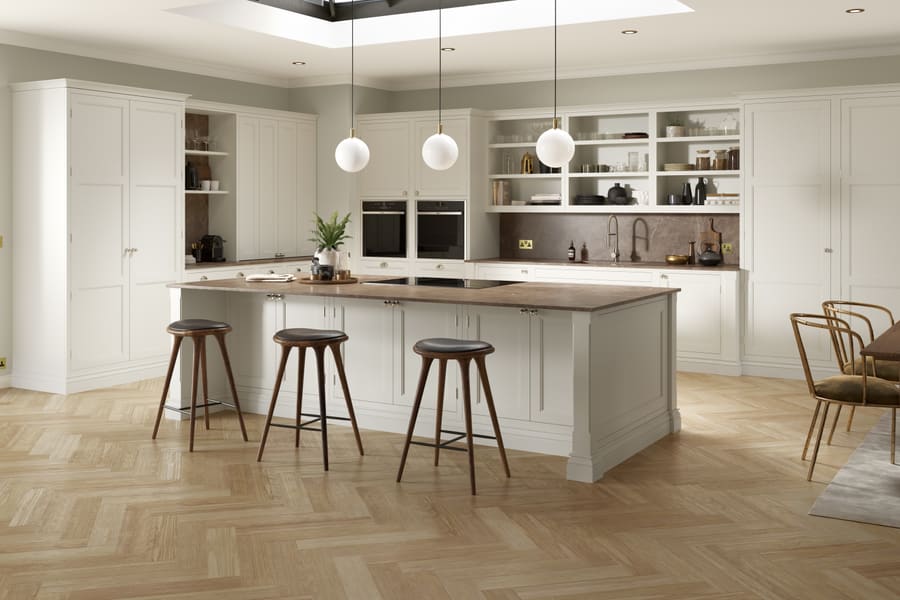 A bright white kitchen with a marble island and pendant lighting